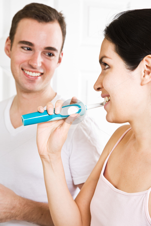 Couple brushing teeth in the bathroom Couple brushing teeth in the bathroom stock photo, A beautiful interracial couple in the bathroom brushing teeth by Suprijono Suharjoto