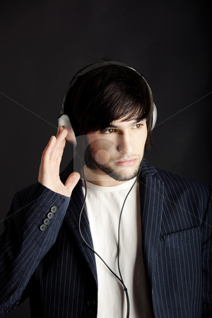 To use this stock image in your creative project, please select the size you need over to the right and click the "Add to Cart" button.
Your downloaded image will come with the Cutcaster watermark removed so don’t worry about the watermark you see on this page. Listening stock photo, Young Man listening to music with headphones by ikostudio