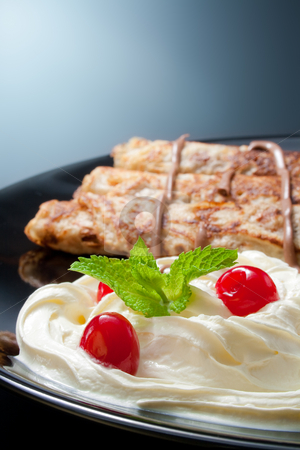 Pancakes with cream and chocolate Pancakes with cream and chocolate stock photo, Three rolled pancakes close-up arranged with cream, cherries, chocolate and sprig mint leaves in black ceramic plate by Miroslav Ivanov