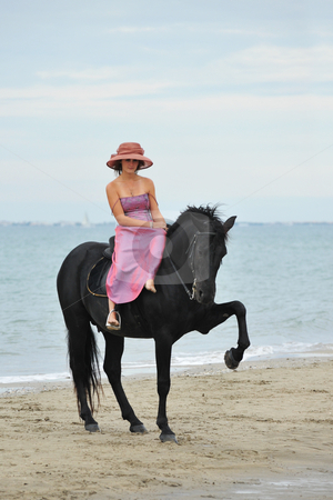 To use this stock image in your creative project, please select the size you need over to the right and click the "Add to Cart" button.
Your downloaded image will come with the Cutcaster watermark removed so don’t worry about the watermark you see on this page. Girl and horse on the beach stock photo, Beautiful black stallion on the beach with young woman by Bonzami Emmanuelle