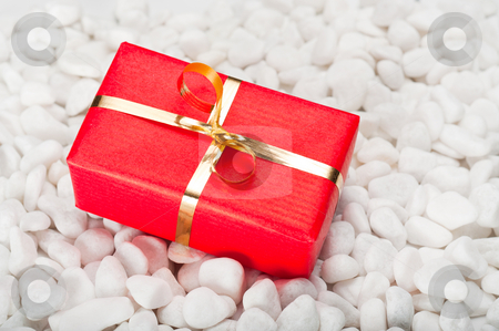 Gift Box on Stones Gift Box on Stones stock photo, Small red and gold gift box on a background of white stones by Timothy Hodgkinson