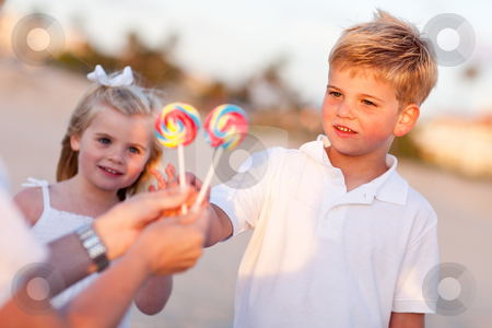 To use this stock image in your creative project, please select the size you need over to the right and click the "Add to Cart" button.
Your downloaded image will come with the Cutcaster watermark removed so don’t worry about the watermark you see on this page. Cute Brother and Sister Picking out Lollipop stock photo, Cute Brother and Sister Picking out Lollipop from Their Mom at the Beach. by Andy Dean