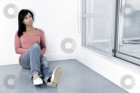 Depressed woman sitting on the floor Depressed woman sitting on the floor stock photo, Depressed black woman sitting against wall looking out window by Elena Elisseeva