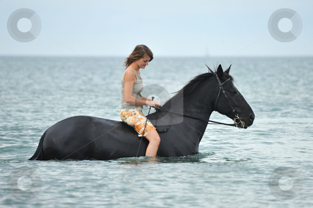 To use this stock image in your creative project, please select the size you need over to the right and click the "Add to Cart" button.
Your downloaded image will come with the Cutcaster watermark removed so don’t worry about the watermark you see on this page. Woman and horse in the sea stock photo, beautiful black horse in the sea and beautiful woman by Bonzami Emmanuelle