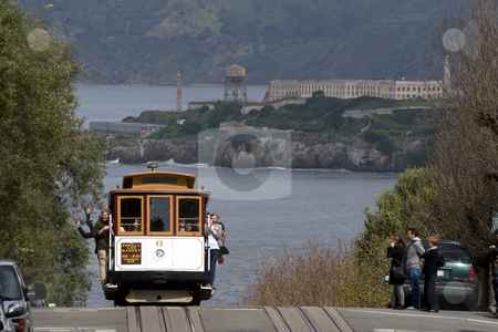 To use this stock image in your creative project, please select the size you need over to the right and click the "Add to Cart" button.
Your downloaded image will come with the Cutcaster watermark removed so don’t worry about the watermark you see on this page. San Francisco Cable Car stock photo, San Francisco cable car on the top of the hill, passengers waving, with the view of Alcatraz in the background by mato020