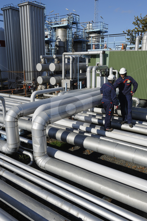 Oil, gas, fuel and pipelines Oil, gas, fuel and pipelines stock photo, two engineers, oil-workers, standing on pipeline construction inside large chemical installation by lagereek