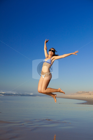 Jumping Jumping stock photo, Beautiful young woman jumping on the beach by ikostudio