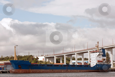 To use this stock image in your creative project, please select the size you need over to the right and click the "Add to Cart" button.
Your downloaded image will come with the Cutcaster watermark removed so don’t worry about the watermark you see on this page. Anchored Freighter stock photo, Anchored Freighter on portuguese shipyard against bridge and sky by Paulo M.F. Pires