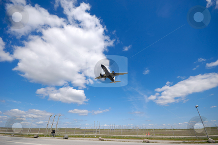 Low plane near airport Low plane near airport stock photo, Plane is going to land. Blue and cloudy sky. by Lars Christensen