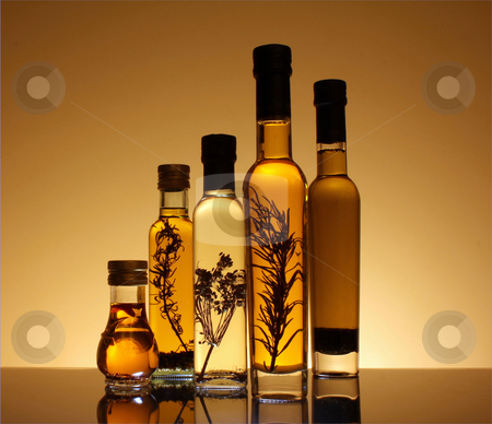 Collection of bottles of olive oil. Collection of bottles of olive oil. stock photo, Collection of bottles of olive oil illuminated from behind and underneath the bottles. The botles has olive oil with peper, rosemary and other seasonings. by marphotography