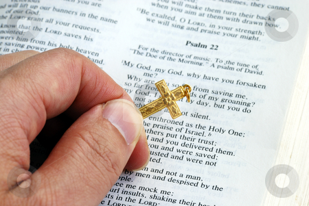 Holding a golden cross while reading the bible Holding a golden cross while reading the bible stock photo, Holding a golden cross while reading the bible by johnkwan