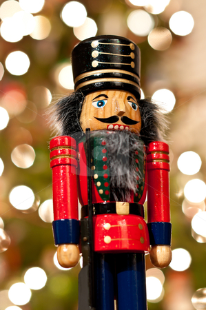 Nutcracker in Front of a Christmas Tree Nutcracker in Front of a Christmas Tree stock photo, A shiny wooden nutcracker stands in front of an out of focus Christmas tree. by Brian Guest