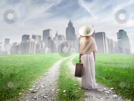 Move Move stock photo, Young woman walking towards a big city with a suitcase in her hand by olly4