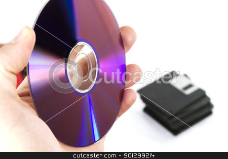 To use this stock image in your creative project, please select the size you need over to the right and click the "Add to Cart" button.
Your downloaded image will come with the Cutcaster watermark removed so don’t worry about the watermark you see on this page. New Media stock photo, A mans hand holding a compact disk, with a stack of old 3 1/2