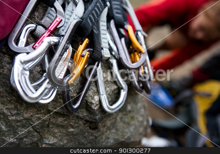 To use this stock image in your creative project, please select the size you need over to the right and click the "Add to Cart" button.
Your downloaded image will come with the Cutcaster watermark removed so don’t worry about the watermark you see on this page. Quickdraws stock photo, A pile of quick draw carabiners with climbers out of focus in the background. by Tyler Olson
