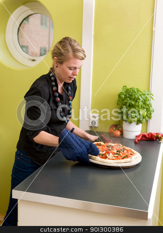 To use this stock image in your creative project, please select the size you need over to the right and click the "Add to Cart" button.
Your downloaded image will come with the Cutcaster watermark removed so don’t worry about the watermark you see on this page. Fresh Pizza stock photo, A young woman takes a fresh pizza out of the oven in her apartment kitchen. by Tyler Olson