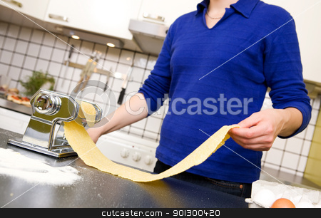 To use this stock image in your creative project, please select the size you need over to the right and click the "Add to Cart" button.
Your downloaded image will come with the Cutcaster watermark removed so don’t worry about the watermark you see on this page. Female Making Pasta stock photo, A young female stretching out pasta over the counter from a manual pasta machine at home in the kitchen. by Tyler Olson