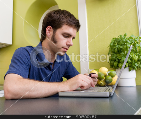 To use this stock image in your creative project, please select the size you need over to the right and click the "Add to Cart" button.
Your downloaded image will come with the Cutcaster watermark removed so don’t worry about the watermark you see on this page. Shopping at Home in Kitchen stock photo, A young male shops online with a credit card at home in the kitchen. by Tyler Olson
