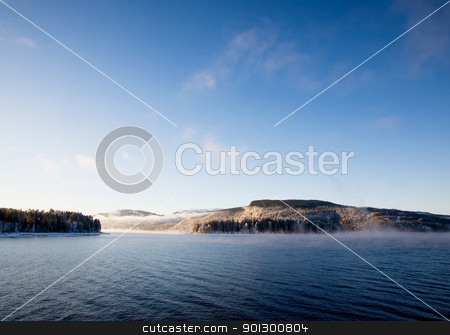 To use this stock image in your creative project, please select the size you need over to the right and click the "Add to Cart" button.
Your downloaded image will come with the Cutcaster watermark removed so don’t worry about the watermark you see on this page. Winter Fjord Landscape stock photo, A winter landscape on a Norwegian Fjord by Tyler Olson