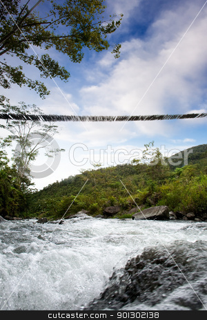 To use this stock image in your creative project, please select the size you need over to the right and click the "Add to Cart" button.
Your downloaded image will come with the Cutcaster watermark removed so don’t worry about the watermark you see on this page. Rive and Bridge stock photo, A hanging bridge over a rapid flowing stream by Tyler Olson