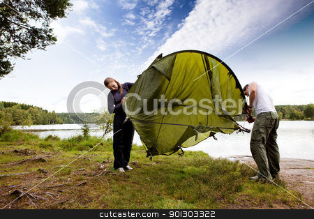 To use this stock image in your creative project, please select the size you need over to the right and click the "Add to Cart" button.
Your downloaded image will come with the Cutcaster watermark removed so don’t worry about the watermark you see on this page. Tent stock photo, A couple setting up a tent in the forest by a lake by Tyler Olson