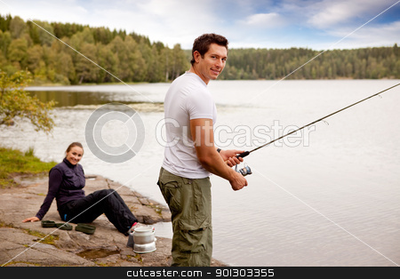 To use this stock image in your creative project, please select the size you need over to the right and click the "Add to Cart" button.
Your downloaded image will come with the Cutcaster watermark removed so don’t worry about the watermark you see on this page. Fishing on Camping Trip stock photo, A man fishing on a lake with camping equipment and woman in background by Tyler Olson