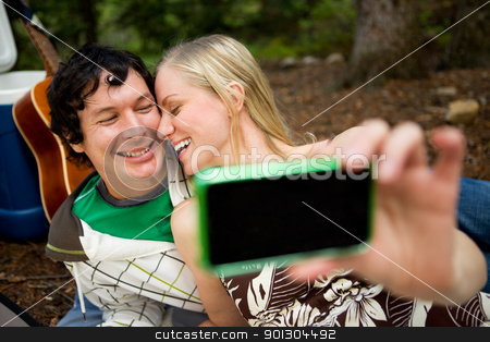 To use this stock image in your creative project, please select the size you need over to the right and click the "Add to Cart" button.
Your downloaded image will come with the Cutcaster watermark removed so don’t worry about the watermark you see on this page. Self Portrait Outdoor Couple stock photo, A happy playful couple on a picnic taking a self portrait by Tyler Olson
