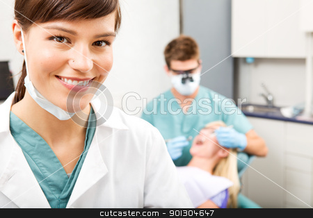To use this stock image in your creative project, please select the size you need over to the right and click the "Add to Cart" button.
Your downloaded image will come with the Cutcaster watermark removed so don’t worry about the watermark you see on this page. Dental Assistant stock photo, A portrait of a dental assistant smiling at the camera with the dentist working in the background by Tyler Olson