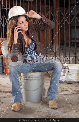 To use this stock image in your creative project, please select the size you need over to the right and click the "Add to Cart" button.
Your downloaded image will come with the Cutcaster watermark removed so don’t worry about the watermark you see on this page. Beautiful Young Construction Worker (5) stock photo, A lovely young brunette, holding a hardhat and wearing workboots, talks on her cell phone as she sits on a bucket amidst the clutter of a long-abandoned warehouse. by Carl Stewart