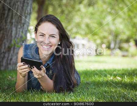 To use this stock image in your creative project, please select the size you need over to the right and click the "Add to Cart" button.
Your downloaded image will come with the Cutcaster watermark removed so don’t worry about the watermark you see on this page. Mixed Race Young Female Texting on Cell Phone Outside stock photo, Attractive Happy Mixed Race Young Female Texting on Her Cell Phone Outside Laying in the Grass. by Andy Dean