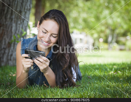 To use this stock image in your creative project, please select the size you need over to the right and click the "Add to Cart" button.
Your downloaded image will come with the Cutcaster watermark removed so don’t worry about the watermark you see on this page. Mixed Race Young Female Texting on Cell Phone Outside stock photo, Attractive Happy Mixed Race Young Female Texting on Her Cell Phone Outside Laying in the Grass. by Andy Dean