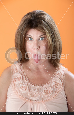 To use this stock image in your creative project, please select the size you need over to the right and click the "Add to Cart" button.
Your downloaded image will come with the Cutcaster watermark removed so don’t worry about the watermark you see on this page. Woman Sticks Tongue Out stock photo, Mature Caucasian woman sticks her tongue out on orange background by Scott Griessel