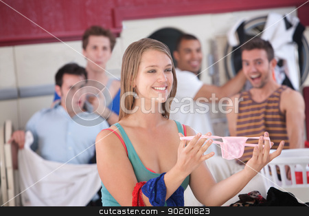 To use this stock image in your creative project, please select the size you need over to the right and click the "Add to Cart" button.
Your downloaded image will come with the Cutcaster watermark removed so don’t worry about the watermark you see on this page. Woman with Thong in Laundromat stock photo, Beautiful young woman holds thong while others laugh in laundromat by Scott Griessel