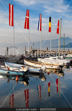 To use this stock image in your creative project, please select the size you need over to the right and click the "Add to Cart" button.
Your downloaded image will come with the Cutcaster watermark removed so don’t worry about the watermark you see on this page. Porto di Cisano - Lago di Garda (Italy) stock photo, Cisano harbor with boats and flags to Garda Lake - Verona - Italy by catalby