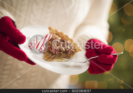 To use this stock image in your creative project, please select the size you need over to the right and click the "Add to Cart" button.
Your downloaded image will come with the Cutcaster watermark removed so don’t worry about the watermark you see on this page. Woman Wearing Red Mittens Holding Plate of Pecan Pie, Peppermint stock photo, Woman Wearing A Sweater and Seasonal Red Mittens Holding A Plate of Pecan Pie with Peppermint Sticks. by Andy Dean