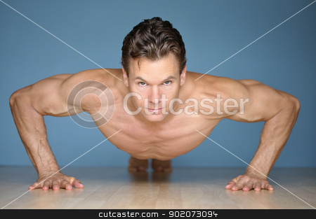 To use this stock image in your creative project, please select the size you need over to the right and click the "Add to Cart" button.
Your downloaded image will come with the Cutcaster watermark removed so don’t worry about the watermark you see on this page. Pushup stock photo, Handsome muscular man looks at camera while performing pushup on floor with blue wall background by Chad Zuber