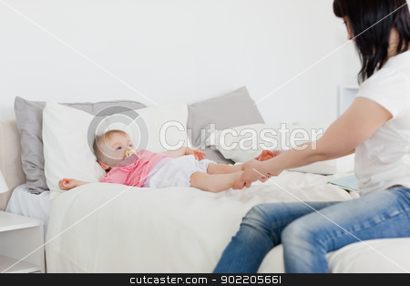 To use this stock image in your creative project, please select the size you need over to the right and click the "Add to Cart" button.
Your downloaded image will come with the Cutcaster watermark removed so don’t worry about the watermark you see on this page. Cute brunette woman playing with her baby while sitting on a bed stock photo, Cute brunette woman playing with her baby while sitting on a bed in her appartment by Wavebreak Media