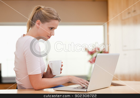 To use this stock image in your creative project, please select the size you need over to the right and click the "Add to Cart" button.
Your downloaded image will come with the Cutcaster watermark removed so don’t worry about the watermark you see on this page. Woman using a laptop while drinking a cup of a tea stock photo, Woman using a laptop while drinking a cup of a tea in her kitchen by Wavebreak Media