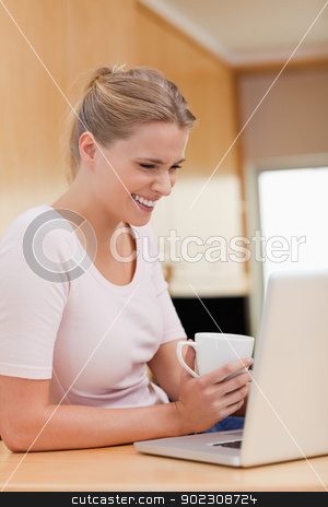 To use this stock image in your creative project, please select the size you need over to the right and click the "Add to Cart" button.
Your downloaded image will come with the Cutcaster watermark removed so don’t worry about the watermark you see on this page. Portrait of a woman using a laptop while drinking a cup of a tea stock photo, Portrait of a woman using a laptop while drinking a cup of a tea in her kitchen by Wavebreak Media