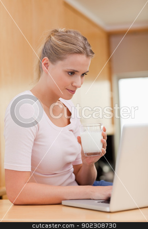 To use this stock image in your creative project, please select the size you need over to the right and click the "Add to Cart" button.
Your downloaded image will come with the Cutcaster watermark removed so don’t worry about the watermark you see on this page. Portrait of a woman using a laptop while drinking milk stock photo, Portrait of a woman using a laptop while drinking milk in her kitchen by Wavebreak Media