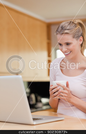 To use this stock image in your creative project, please select the size you need over to the right and click the "Add to Cart" button.
Your downloaded image will come with the Cutcaster watermark removed so don’t worry about the watermark you see on this page. Portrait of a young woman using a laptop while drinking coffee stock photo, Portrait of a young woman using a laptop while drinking coffee in her kitchen by Wavebreak Media