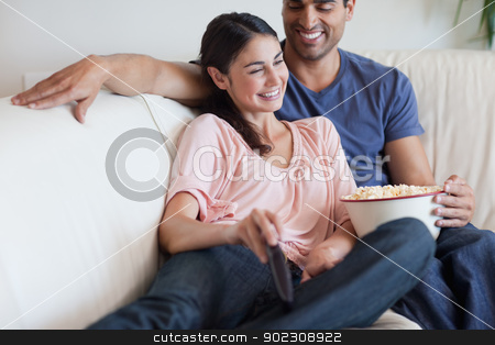 To use this stock image in your creative project, please select the size you need over to the right and click the "Add to Cart" button.
Your downloaded image will come with the Cutcaster watermark removed so don’t worry about the watermark you see on this page. Delighted couple watching TV while eating popcorn stock photo, Delighted couple watching TV while eating popcorn in their living room by Wavebreak Media