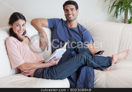 To use this stock image in your creative project, please select the size you need over to the right and click the "Add to Cart" button.
Your downloaded image will come with the Cutcaster watermark removed so don’t worry about the watermark you see on this page. Woman reading a book while her husband is watching TV stock photo, Woman reading a book while her husband is watching TV in their living room by Wavebreak Media