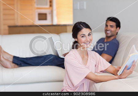 To use this stock image in your creative project, please select the size you need over to the right and click the "Add to Cart" button.
Your downloaded image will come with the Cutcaster watermark removed so don’t worry about the watermark you see on this page. Woman reading a book while her boyfriend is using a laptop stock photo, Woman reading a book while her boyfriend is using a laptop in their living room by Wavebreak Media