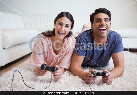 To use this stock image in your creative project, please select the size you need over to the right and click the "Add to Cart" button.
Your downloaded image will come with the Cutcaster watermark removed so don’t worry about the watermark you see on this page. Playful couple playing video games stock photo, Playful couple playing video games in their living room by Wavebreak Media