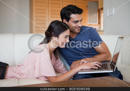 To use this stock image in your creative project, please select the size you need over to the right and click the "Add to Cart" button.
Your downloaded image will come with the Cutcaster watermark removed so don’t worry about the watermark you see on this page. Smiling young couple using a laptop stock photo, Smiling young couple using a laptop in their living room by Wavebreak Media