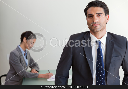 To use this stock image in your creative project, please select the size you need over to the right and click the "Add to Cart" button.
Your downloaded image will come with the Cutcaster watermark removed so don’t worry about the watermark you see on this page. Handsome businessman posing while his colleague is working stock photo, Handsome businessman posing while his colleague is working in an office by Wavebreak Media