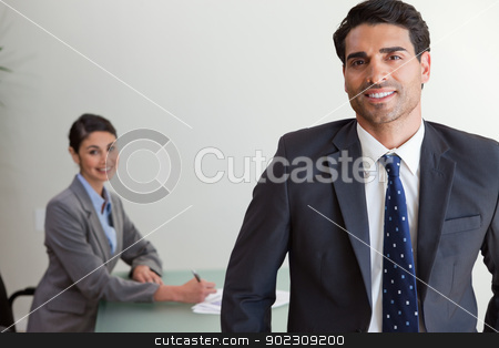 To use this stock image in your creative project, please select the size you need over to the right and click the "Add to Cart" button.
Your downloaded image will come with the Cutcaster watermark removed so don’t worry about the watermark you see on this page. Good looking businessman posing while his colleague is working stock photo, Good looking businessman posing while his colleague is working in an office by Wavebreak Media