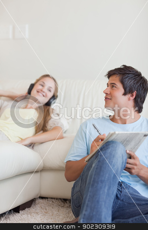 To use this stock image in your creative project, please select the size you need over to the right and click the "Add to Cart" button.
Your downloaded image will come with the Cutcaster watermark removed so don’t worry about the watermark you see on this page. Portrait of a man doing crosswords while his girlfriend is liste stock photo, Portrait of a man doing crosswords while his girlfriend is listening to music in their living room by Wavebreak Media