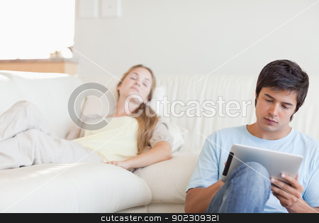 To use this stock image in your creative project, please select the size you need over to the right and click the "Add to Cart" button.
Your downloaded image will come with the Cutcaster watermark removed so don’t worry about the watermark you see on this page. Man using a tablet computer while his girlfriend is sleeping stock photo, Man using a tablet computer while his girlfriend is sleeping in their living room by Wavebreak Media